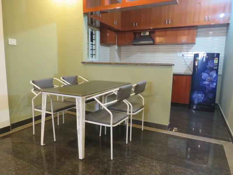 2 BHK four-seater dining table and open kitchen