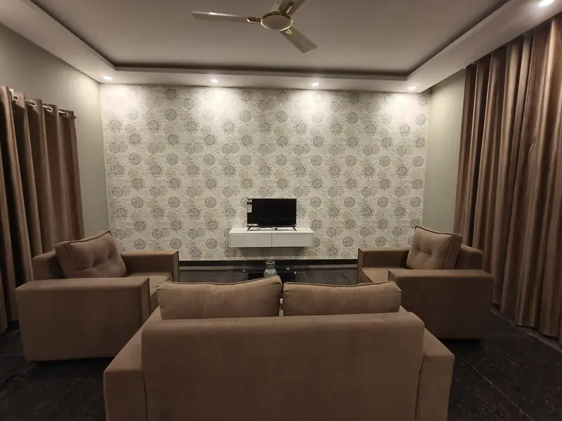 Spacious 2 BHK living room with sofa set and TV