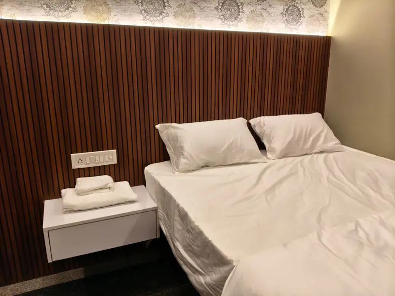 Bed made with fresh white linen and towels